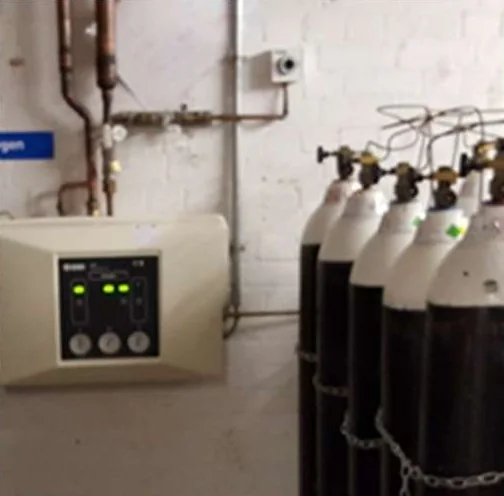 Area alarm panel beside an oxygen cylinder manifold